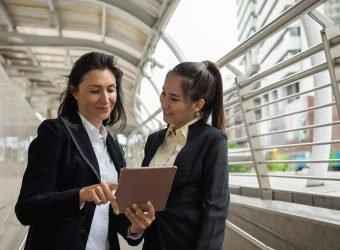 Two business women with tablet in city