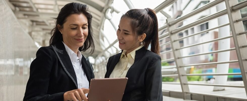 Two business women with tablet in city