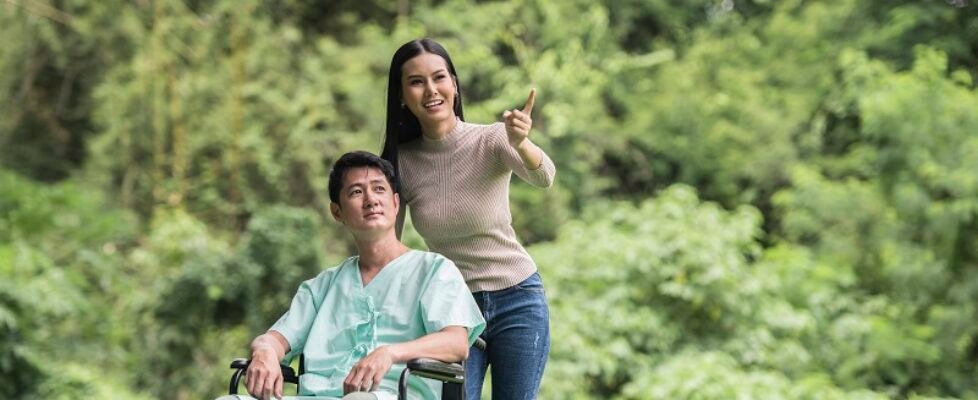 Disabled man in wheelchair and girlfriend in the park