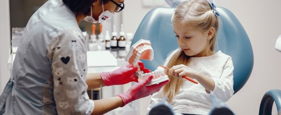 Cute little girl sitting in the dentist's office