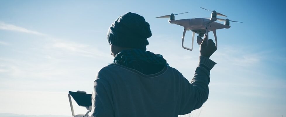 Man operating a drone with remote control. Dark silhouette again
