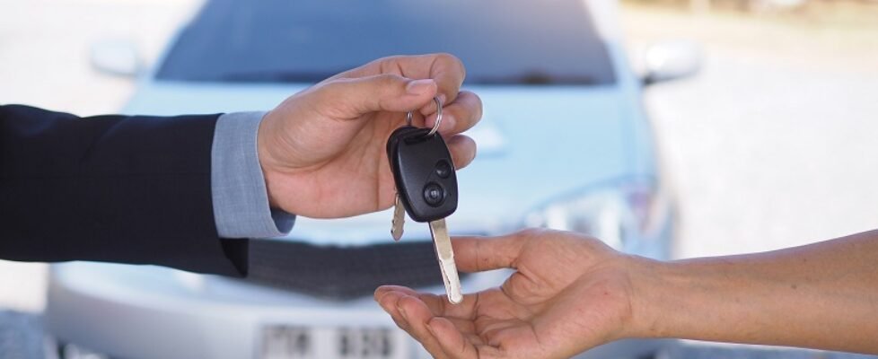 Car salesmen send keys to new car owners. Used car sales agency, car rental