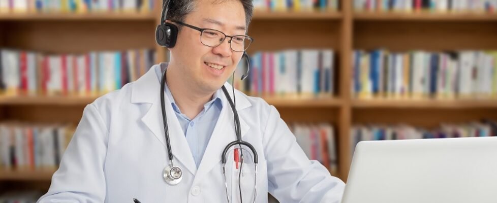 an Asian doctor who is remotely consulting with a patient. Telehealth concept