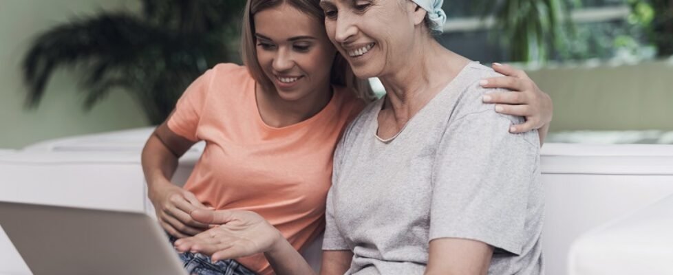 People are looking at something on the laptop and smiling.