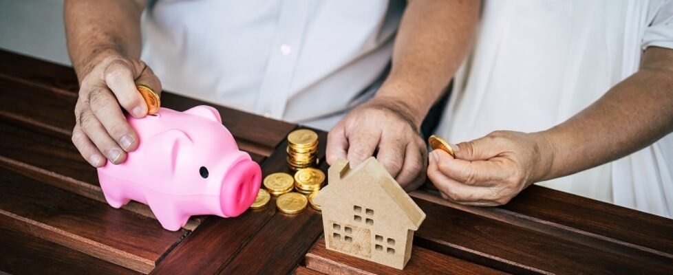 Elderly Couples talking about finance with piggy bank