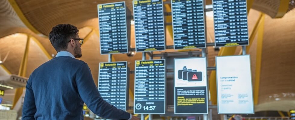 man checking his flight on the timetable display at the airport