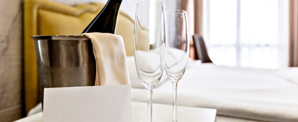 Honeymoon concept. Champagne bucket near bed in a hotel room