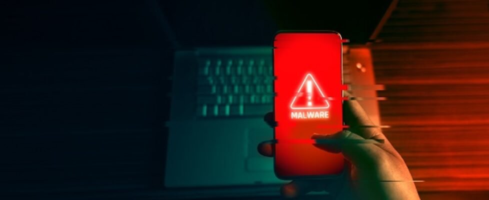 An anonymous hacker and uses a malware with mobile phone to hack password the personal data and money from Bank accounts. The concept of cyber crime.