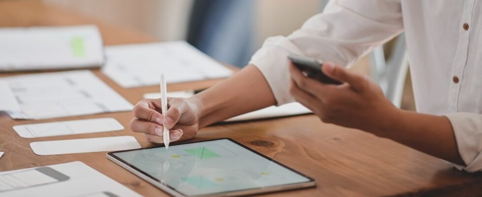 Cropped shot of youngl ux web developer working on her project while using digital tablet