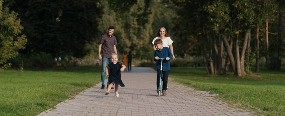 School boy riding a scooter in the park