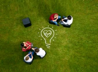 People talking on chairs in grass