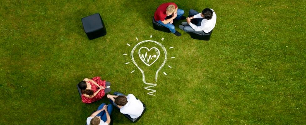 People talking on chairs in grass