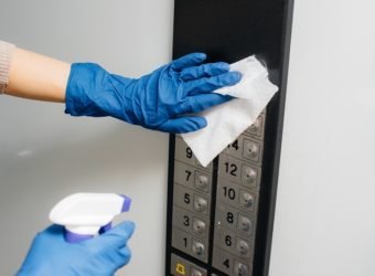 A young woman disinfects and cleans keys in an Elevator during a global pandemic. Stay at home.