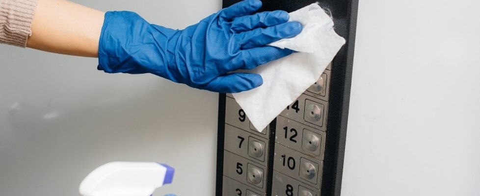 A young woman disinfects and cleans keys in an Elevator during a global pandemic. Stay at home.