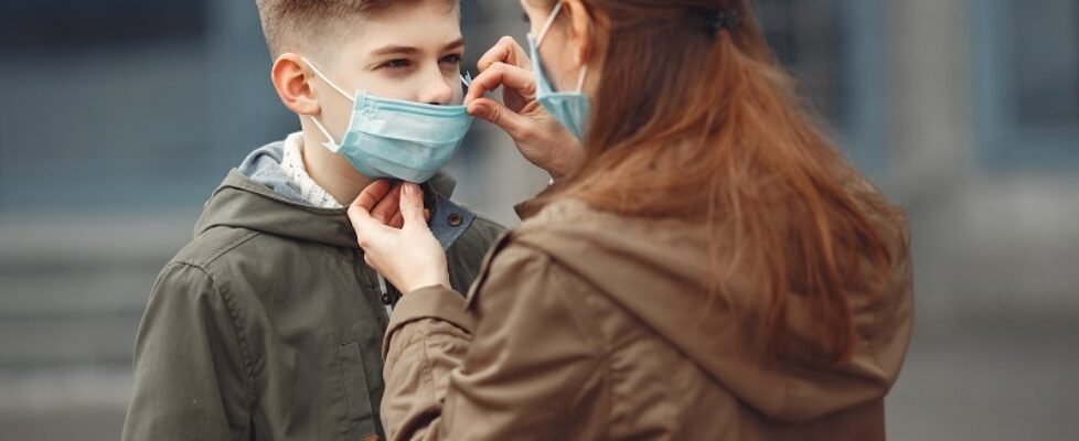 A boy and mother are wearing protective masks
