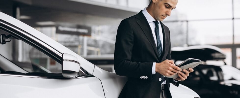 Young handsome man in car showroom