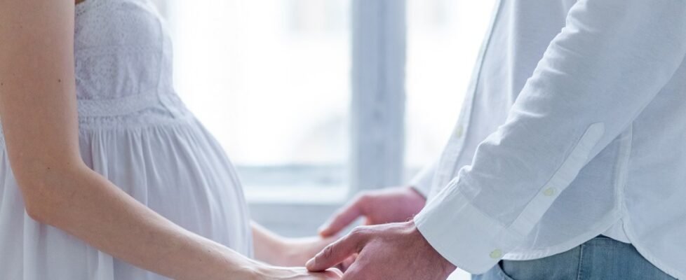 The young couple dressed in white standing at home