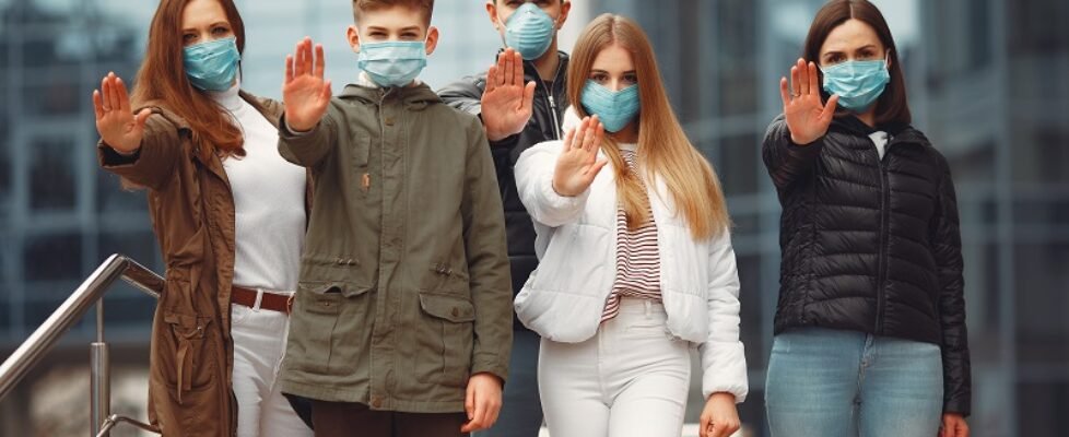 People wearing protective masks are showing stop sign by hands
