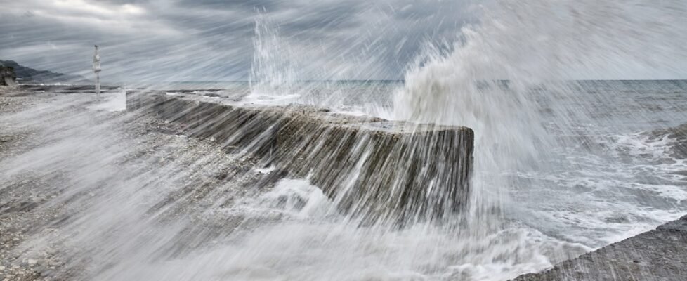 Splashes from the raging waves fly to the shore, in motion