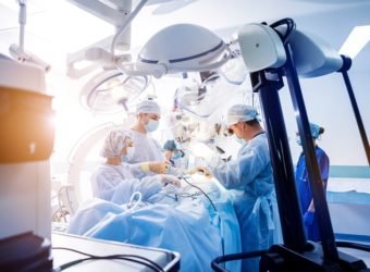 Spinal surgery. Group of surgeons in operating room with surgery equipment.