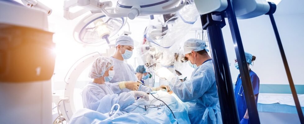 Spinal surgery. Group of surgeons in operating room with surgery equipment.