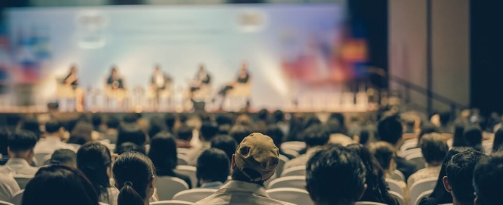Rear view of Audience listening Speakers on the stage in the con