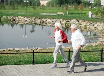 Active Senior Couple Running by Lake