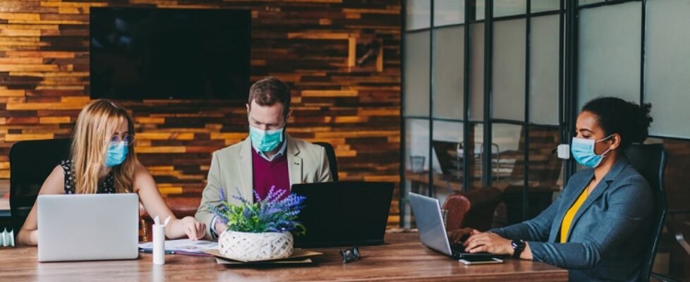 Businesspeople working with face masks in the office during COVID-19 pandemic