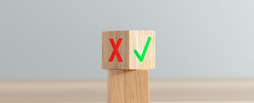 Stacked wooden blocks and false and true symbols, Choice no or yes for evaluation.
