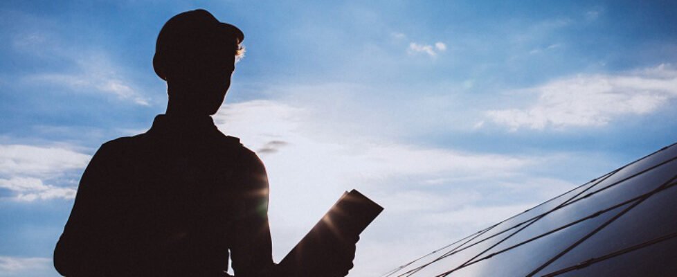 Man worker in the firld by the solar panels