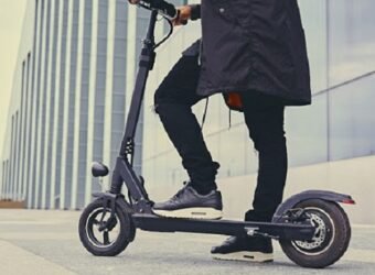 Close up image of a man on an electric scooter.