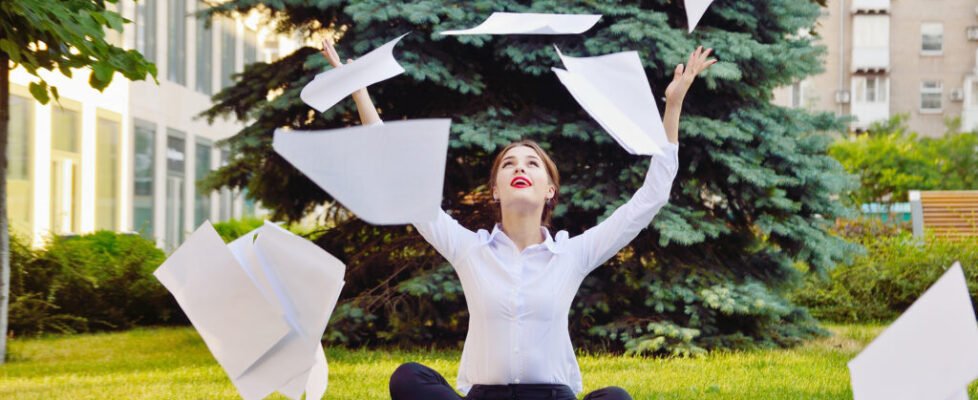 Office yoga. Business lady in lotus pose sits on green grass thr