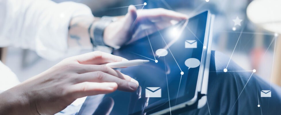 Blogger using mobile touch pad for sending at social network message.Closeup view of male hands using stylus pen for working on electronic tablet device.