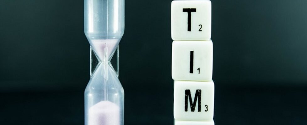 Dice reading TIME with a sand clock beside