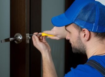 Handyman repair the door lock in the room. Closeup of man repairing the doorknob.