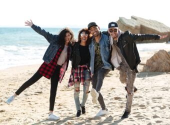Smiling african friends walking outdoors at beach.