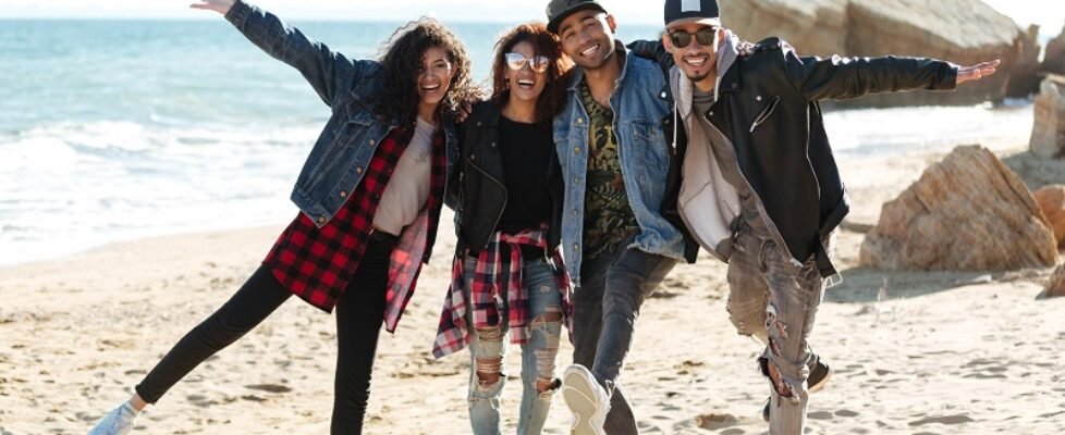 Smiling african friends walking outdoors at beach.