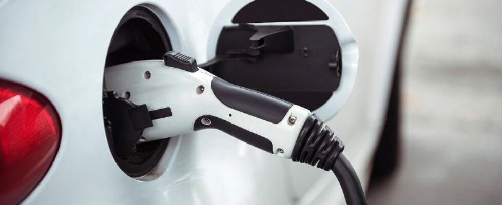 Close-up of car being charged with electric car charger at charging station