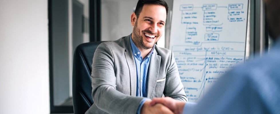 Good deal. Two business people shaking hands while sitting at th