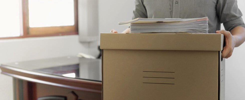 Upset employee packing belongings in box, frustrated stressed ma