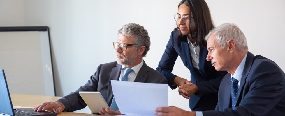 Concentrated partners using laptop and working with documents
