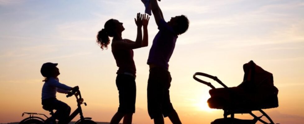 Silhouette of happy family playing at sea coast