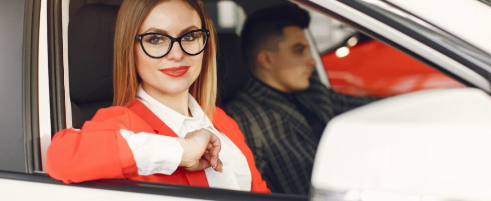 Couple in a car salon. Family buying the car. Elegant woman with her boyfriend.
