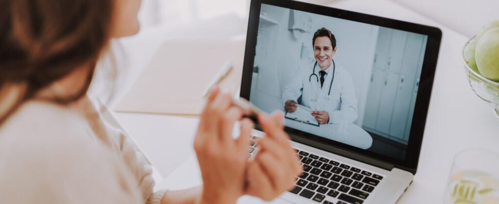 Cheerful doctor making video-call to his patient at home