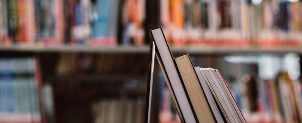 laptop computer and book on workplace in library room,Education