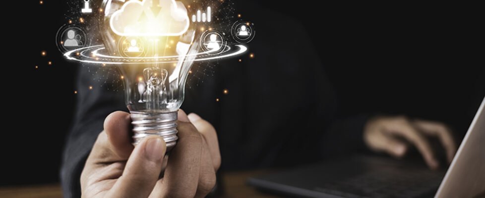 Hand holding lightbulb with cloud computing and technology icons