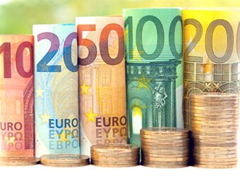 Ten, twenty, fifty, one hundred, two hundred and coins euro rolled bills banknotes on green blurred bokeh background. Histogram from the euro. Concept of currency growth, savings