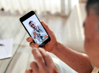 Happy old man meet his doctor via video call by smart phone at h