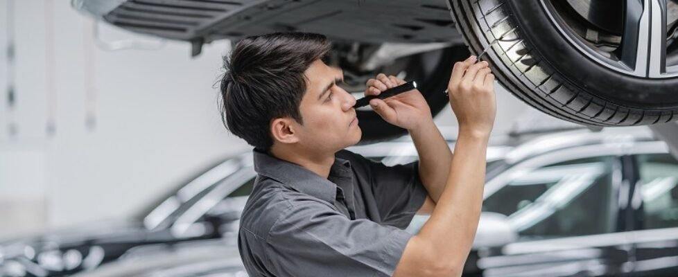 Asian mechanic Checking and torch tire in maintainance service c