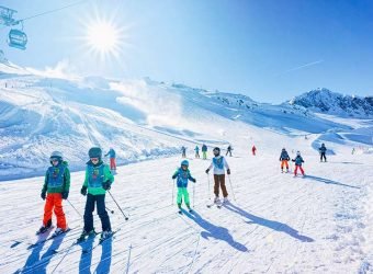Group of Children Skiers with instructor skiing in Hintertux Glacier